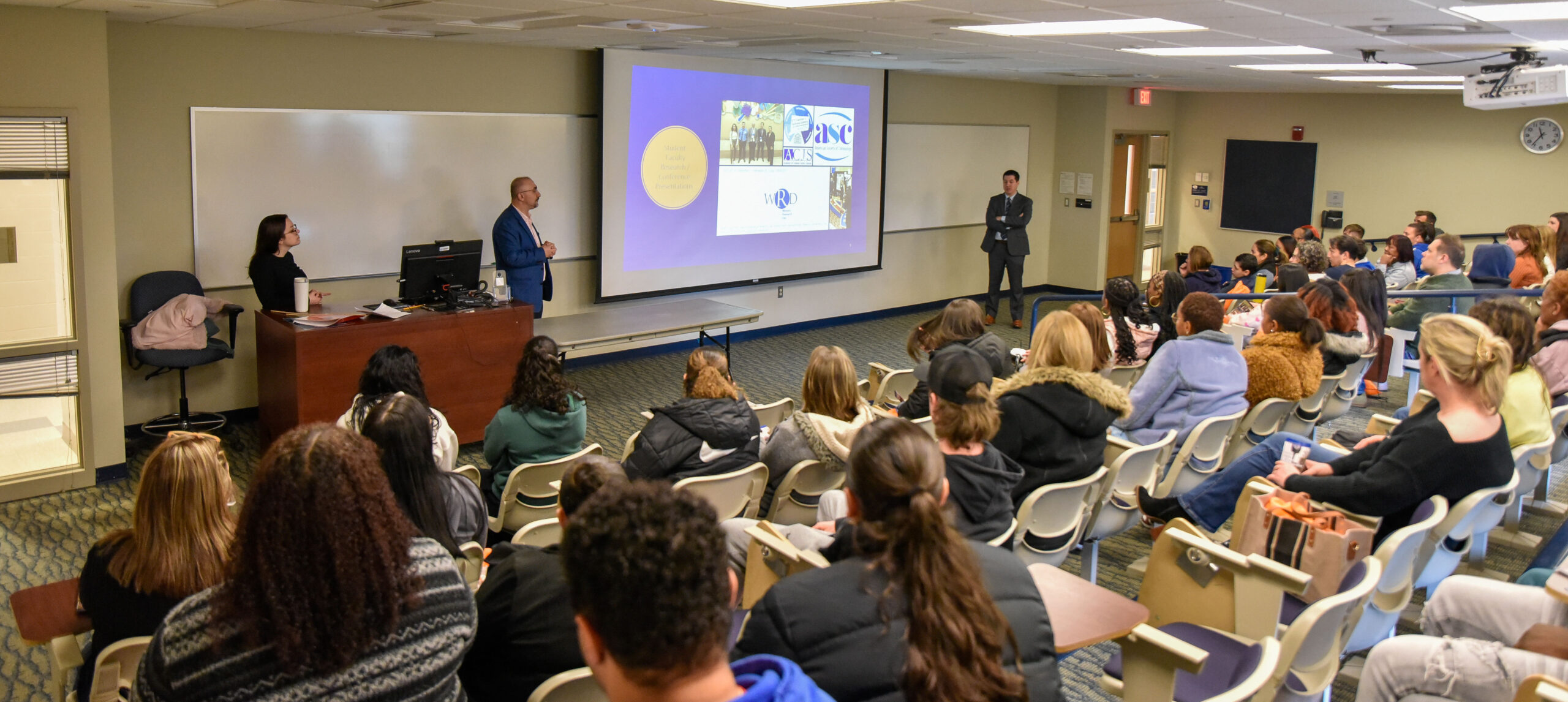 students sitting and listening to a presentation